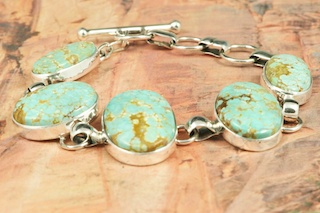 5 Beautiful Genuine Number 8 Mine Turquoise Stones set in Sterling Silver Bracelet. Created by Navajo Artist Tony Garcia. Signed by the artist. The Number 8 mine is located in Eureka County Nevada. Since 1976 there has been no Number 8 Turquoise mined. There is however, an existing stock pile that Mr. Dowell Ward, the last owner of the Number 8 mine, had stocked away for later sorting. The Turquoise is a collector's item--because once the reserve is gone there will be no more material released onto the market. The Gold Mining Company owns the claim to the Number 8 mine and it has been swallowed up by the gold mining operations. This is some of the last Number 8 Turquoise to be had and will be a great addition to your collection.  